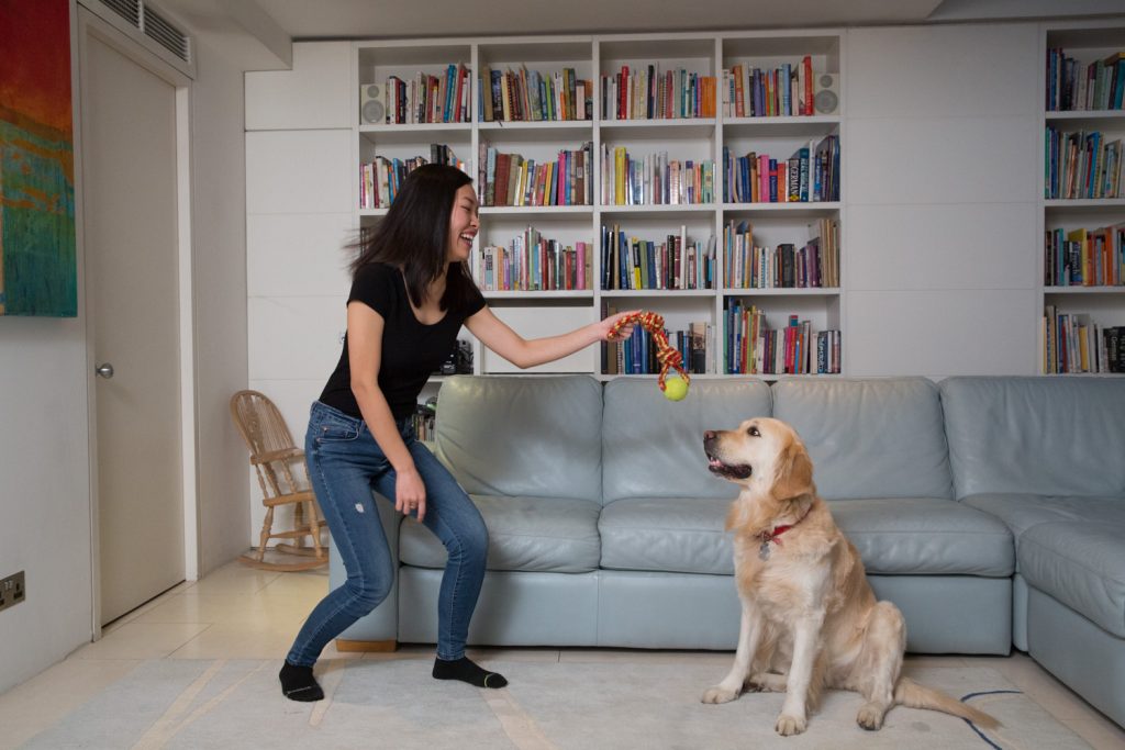 woman playing with dog to show how posture makes you more photogenic