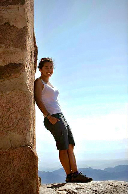 woman leaning against wall on a hike showing how to pose for a photo on holiday