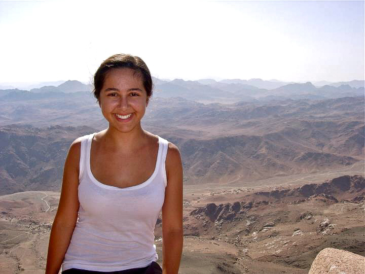 woman posing for photo in front of mountains showing how to look good for pictures on vacation