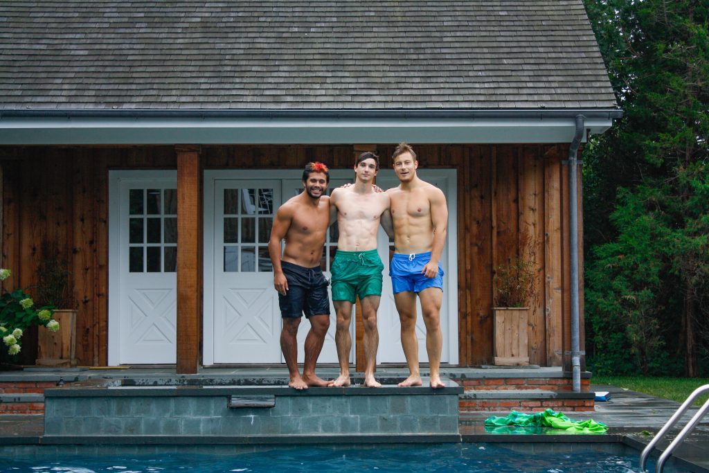 male friends posing for a photo by a pool